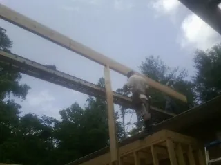 Carpenter setting a ridge beam over a new addition frame — Ice Dam Removal by Roofing Brothers in Brantingham